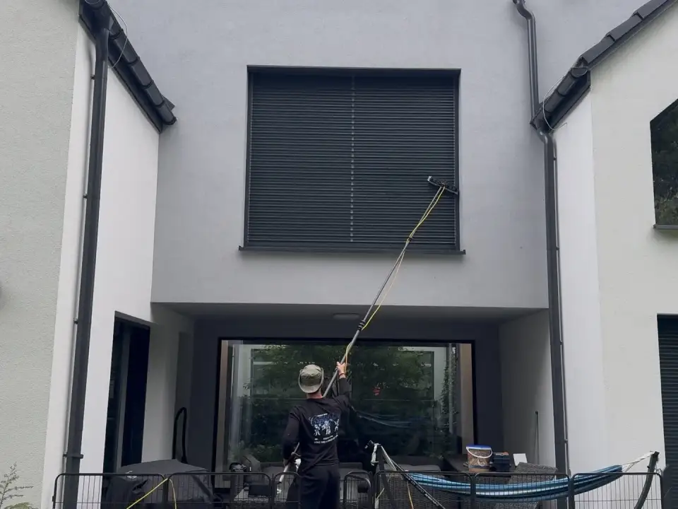 Mycie żaluzji fasadowej na piętrze kijem z wodą demineralizowaną