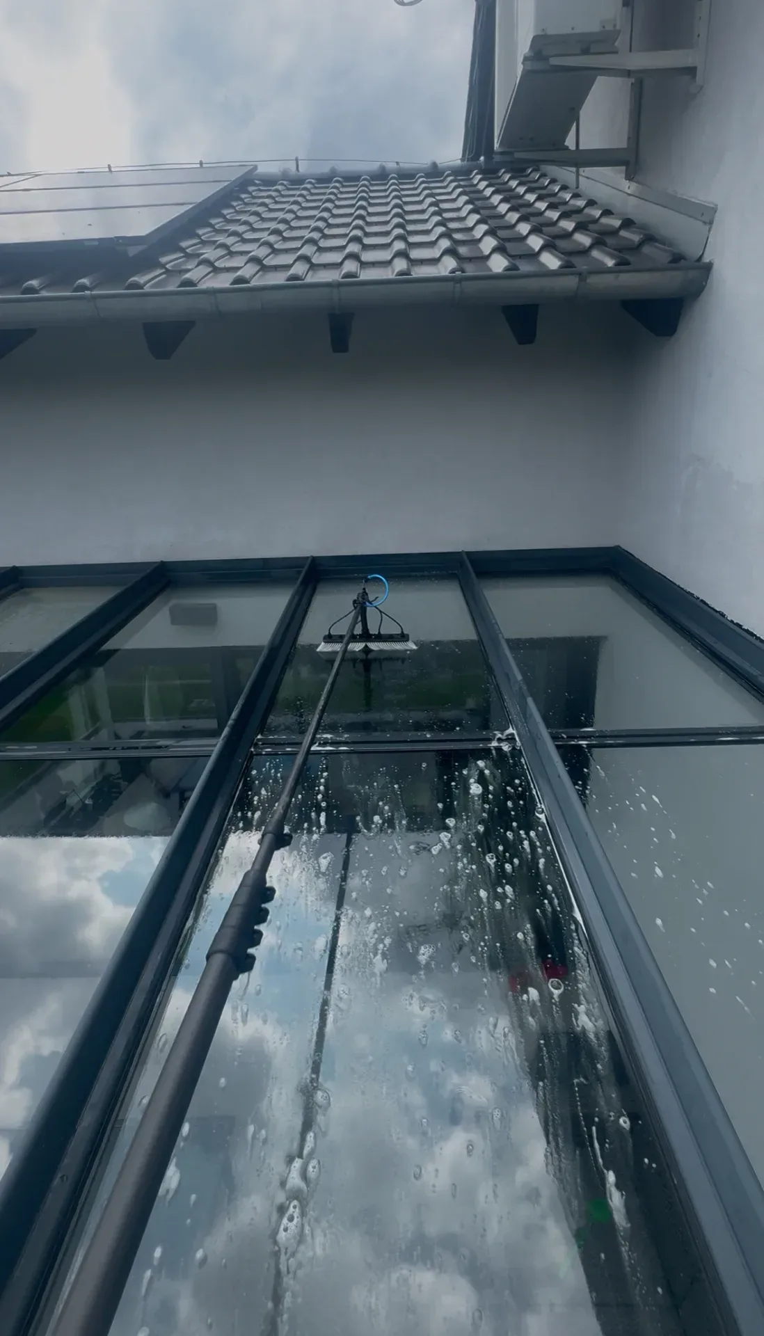 Szklany dach ogrodu zimowego w pianie podczas mycia, Lubliniec